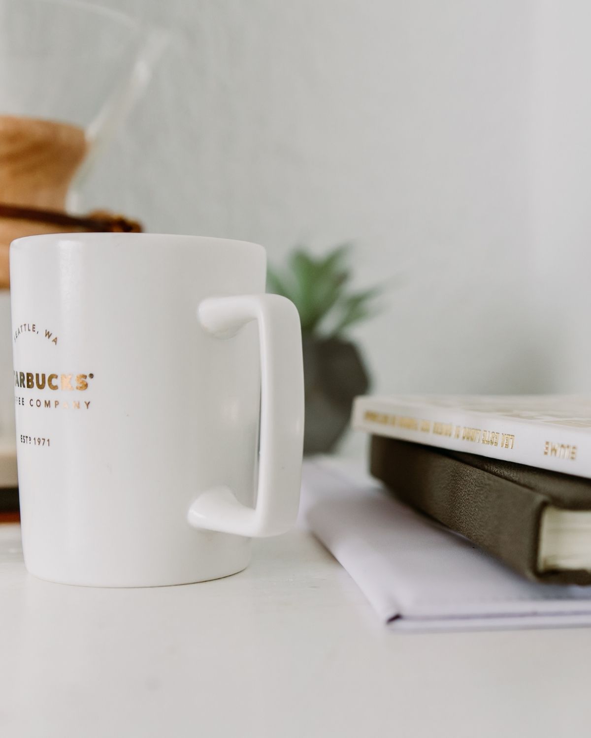 white starbucks mug with books on desk